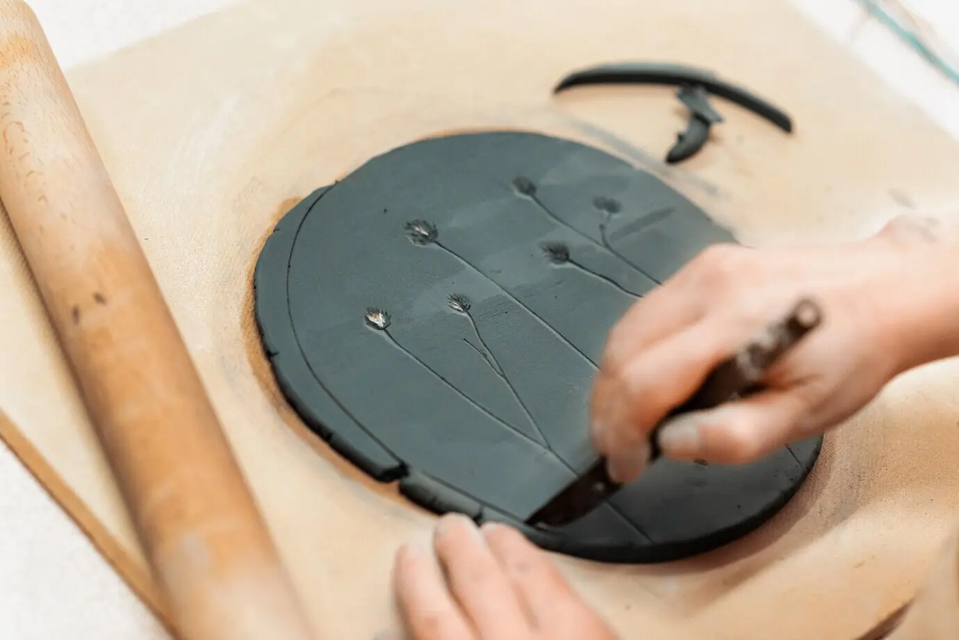 El maestro del modelado de cerámica trabajando en un estudio, formando un círculo con arcilla alisada.