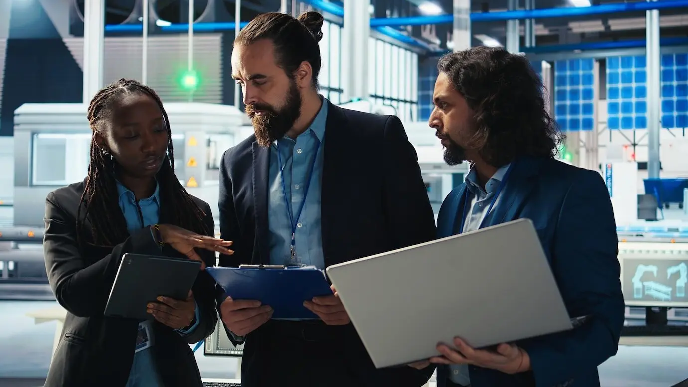 Ingenieros de una fábrica de fotovoltaicos trabajando en equipo e investigando soluciones solares más baratas.