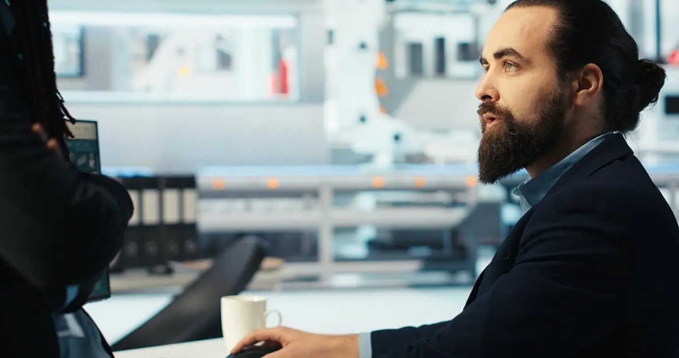El gerente de una fábrica fotovoltaica realiza una lluvia de ideas con un colega mientras analizan datos.